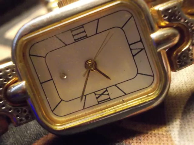 Montre femme dorée habillée marquée B calligrame au dos.