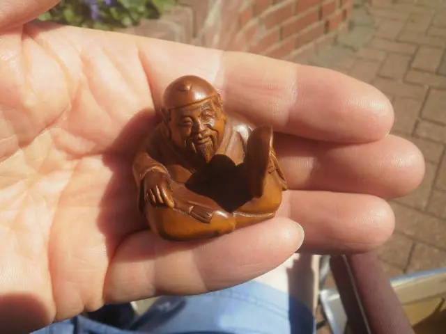 2b.. Hand Carved wood netsuke Japanese man sits to sell mask collectable figure