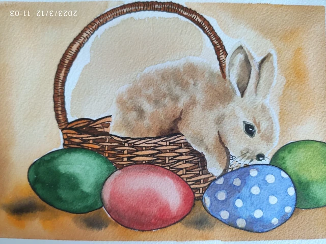 Süßes Häschen im Korb mit bunten Eiern. Ostern. Kleines Aquarell. Original.