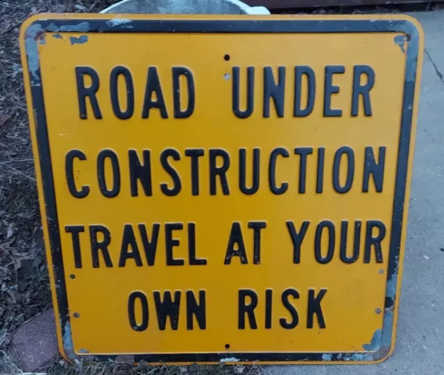 ROAD UNDER CONSTRUCTION "TRAVEL AT YOUR OWN RISK"  Yellow Road Sign