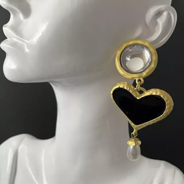 Un paio di orecchini a forma di cuore con perla nera in oro