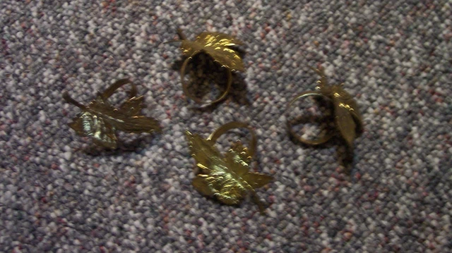 Juego de 4 anillos portaserpinas de metal en tono dorado con diseño de hoja de arce en buen estado