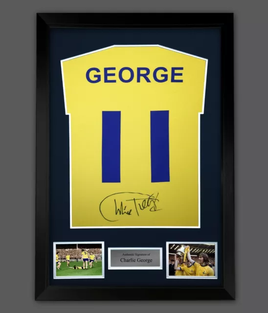 Charlie George Hand Signed Yellow T-Shirt In A Framed  Display. Arsenal Legend