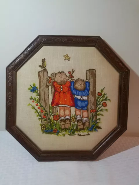 Punto de cruz vintage con aguja para niños y niñas mirando sobre cerca enmarcada