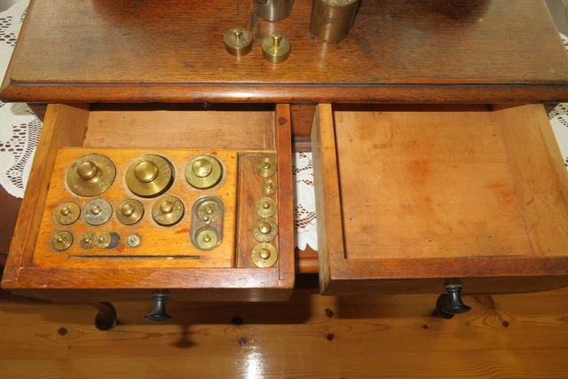 Apothekerwaage , Tisch, Glaswaren, Bügeleisen, Kupferwärmflasche und Bücher 2