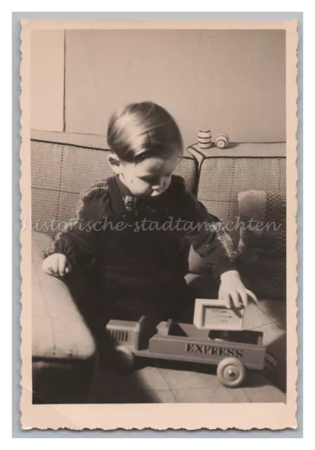 Kind spielt mit Holzspielzeug - LKW - Altes Foto 1950er