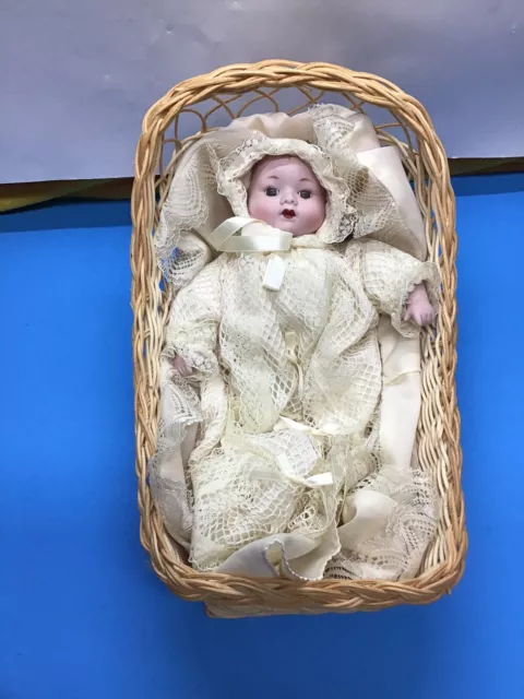 Vintage Bisque Baby Doll w/ pull string for music, in a bassinet (woven)