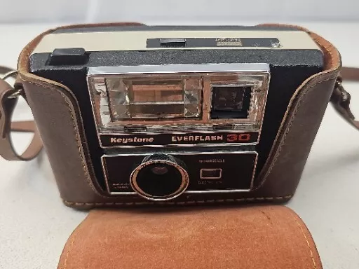 Vista superior de una cámara analógica retro, un carrete negativo, un  pasaporte y un cuaderno sobre una mesa de madera