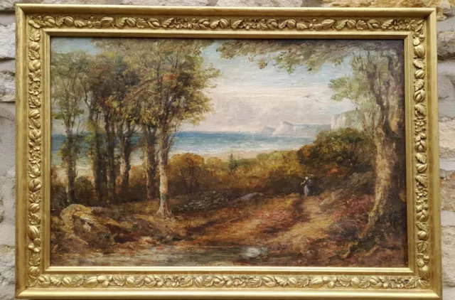 EARLY 19th CENTURY COASTAL LANDSCAPE WITH WOODLAND AND FIGURE.