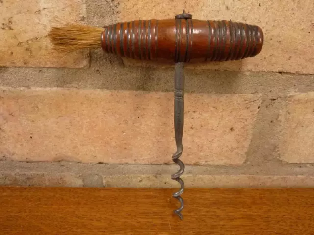 a nice antique corkscrew and brush with turned wooden handle