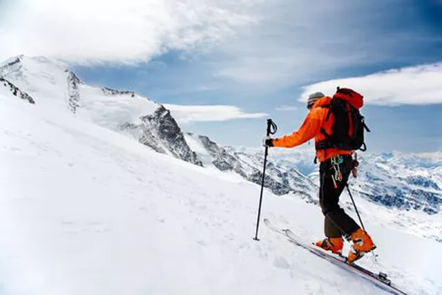 Einsamer Alping-Touring-Skifahrer auf dem Big Verra-Gletscher; Im Hintergrund di