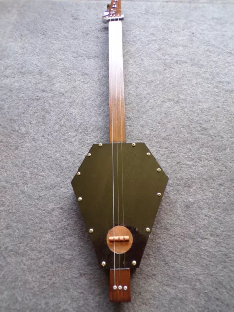 3 string fretless cigar box guitar by Deadfinger with coffin shaped body .