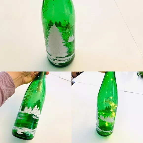 Escena de nieve de invierno pintada a mano con árboles en botella de vino verde con luces