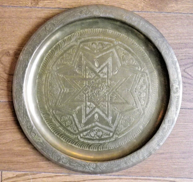 Ancien grand plat rond en cuivre gravé. Signé d'un marteau. Protection en verre