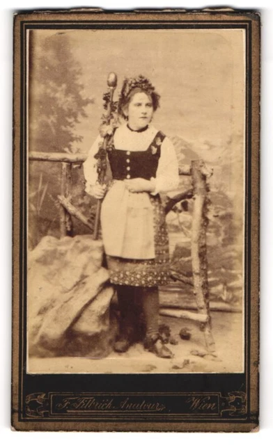 Fotografie Atelier Flora, Wien, junge Frau im Trachtenkleid mit Stab und Blumen