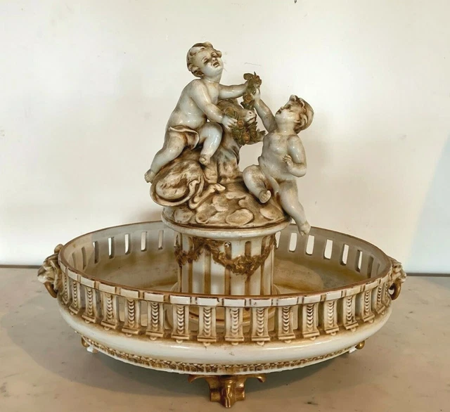 Groupe en porcelaine a rehaut doré Décor de d'angelots sur un socle XX siècle