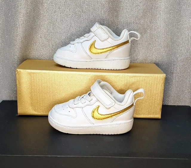 White nike trainers sales with gold tick