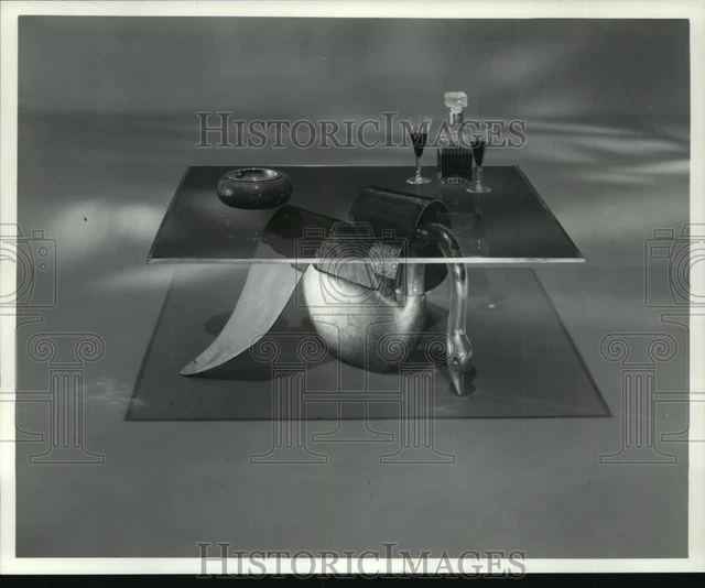 1983 Press Photo wings of a brass swan support glass top for a cocktail table.