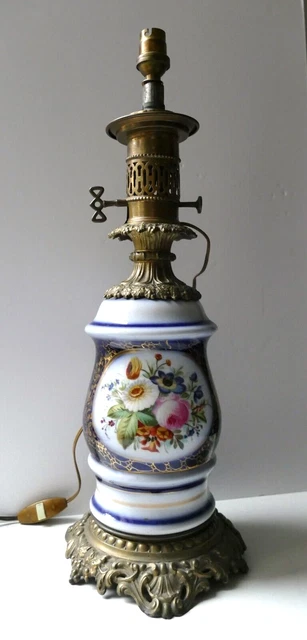 Lampe à pétrole en porcelaine à décor polychrome floral, la monture en