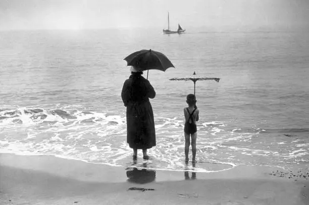 holiday-makers standing under umbrellas beach Lowestoft 1934 Old Photo