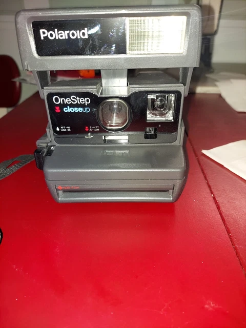 Cámara fotográfica instantánea vintage negra Polaroid 600 primer paso con correa