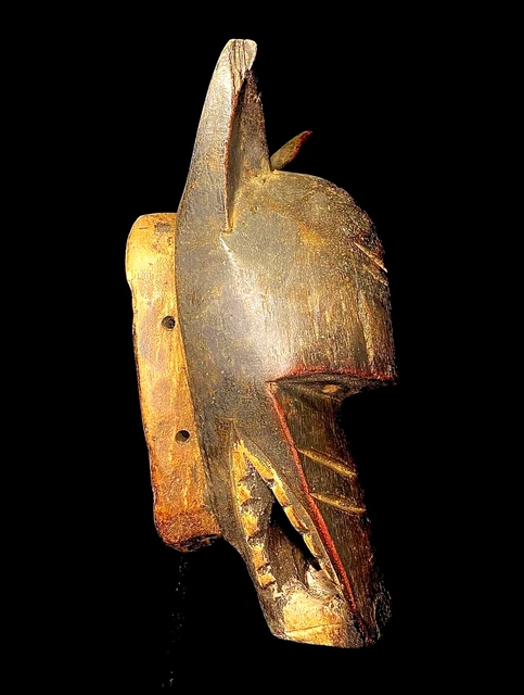 Maschera africana antica intagliata a mano in legno con decorazioni murali...