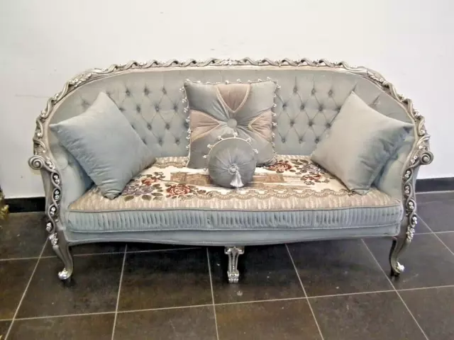 Un canapé gris avec des motifs Style Louis XV