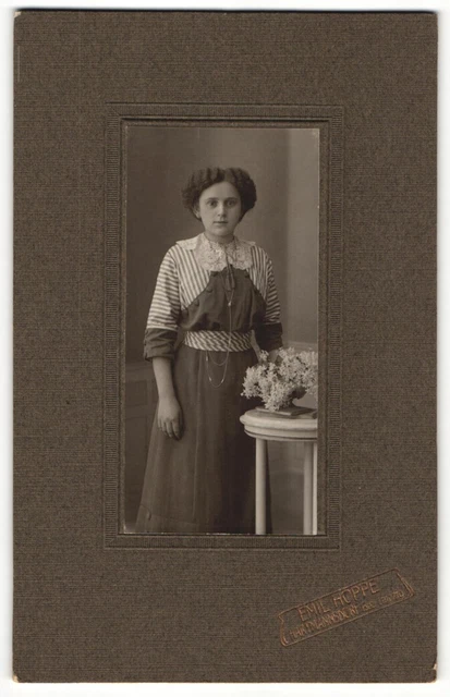Fotografie Emil Hoppe, Hartmannsdorf, Portrait modisch gekleidete Dame mit Blum