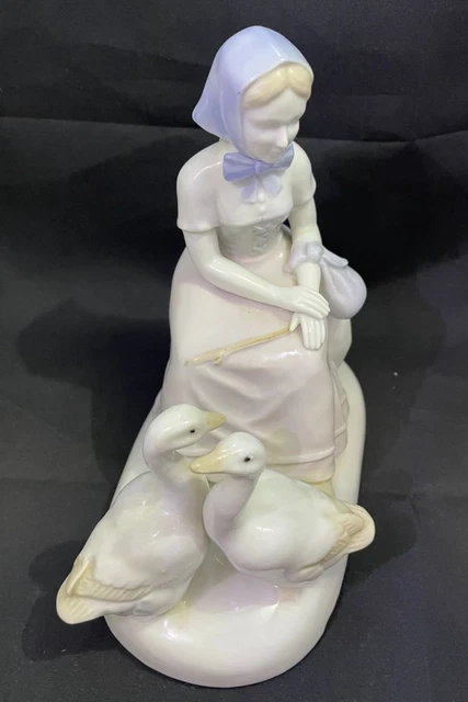 Estatuilla de porcelana para dama con cisnes