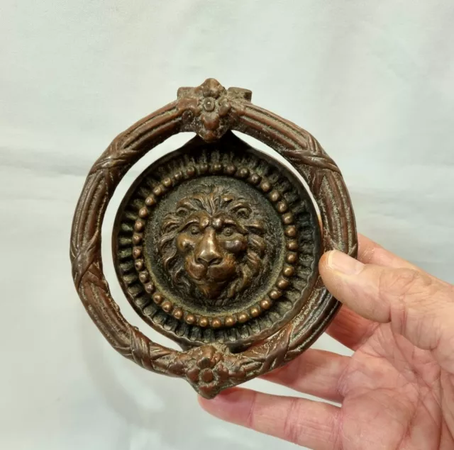 Antique brass lion's head door knocker with integral strike plate and new bolts.