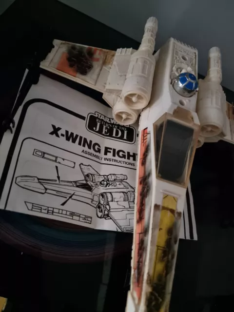 Luchador Star Wars X-Wing de colección, dañado en batalla con alas e inserto en funcionamiento.