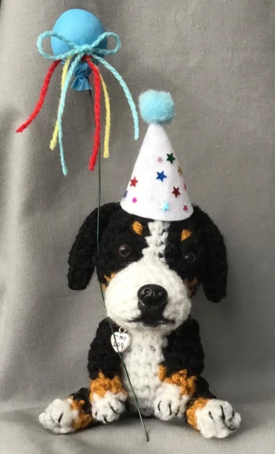 Bernese Mountain Dog Wearing A Party Hat And Holding A Blue Balloon