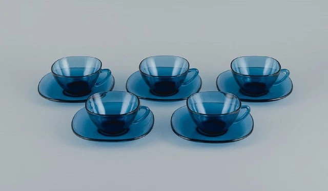 Vereco, France, a set of four teacups and matching saucers in blue glass.