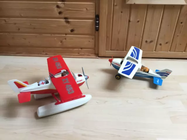 Zwei Plastik Flugzeuge einemal in rot und einmal in Blau von Albatros