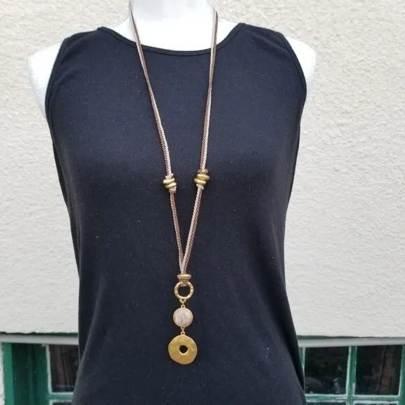 brown and tan cord necklace with tiered gold tone pendant