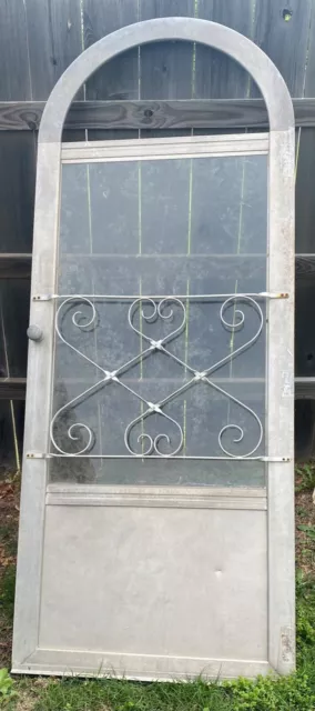 Vintage metal storm/door with arch top w/decorative attached grill
