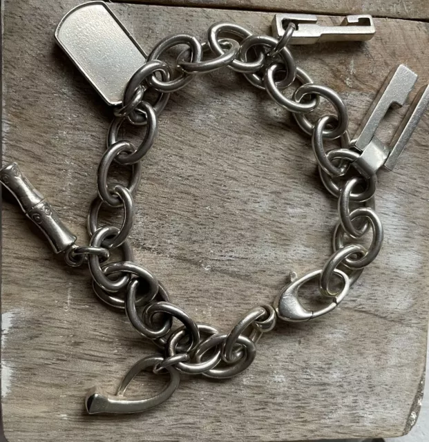 Lot 2574 - A Gucci sterling silver charm bracelet,