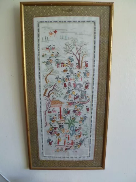 A framed oriental embroidery on silk of village scene, 26" x 13".