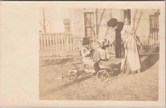 Real Photo RPPC Postcard Child on Four-Wheeled Bike in House Yard c1910s Unused