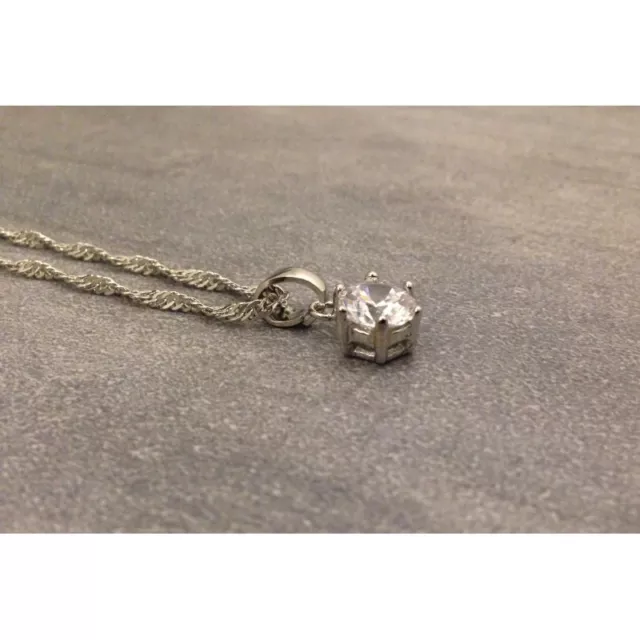 Chaine torsadé en argent avec un pendentif avec une pierre blanche