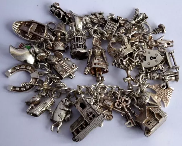 Vintage heavy solid silver charm bracelet & 34 silver charms inc opening,moving