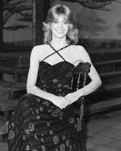 OLIVIA NEWTON-JOHN 1970's smiling for press seated on chair in black dress 8x10