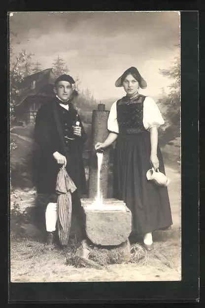 Foto-AK Mann und Frau in Tracht vor dörflicher Studiokulisse