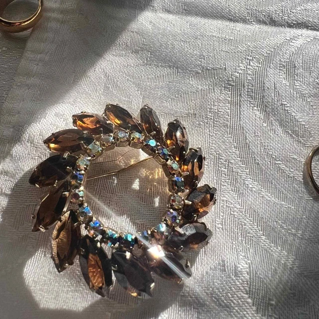Brooch, 2” round with 15 chocolate stones and 20 smaller iridescent stones