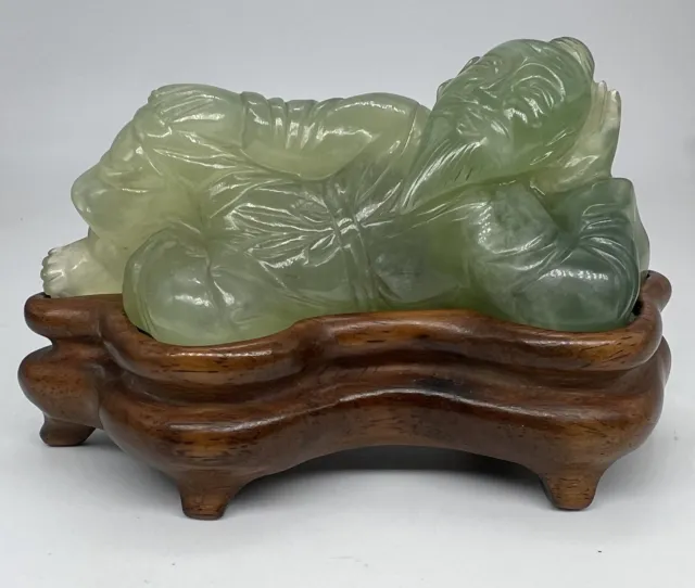 A Finely Carved Chinese Jade Man Resting with Wooden Stand