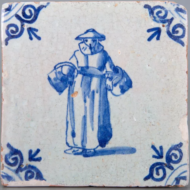 Nice Dutch Delft Blue tile, standing figure with baskets, mid 17th century.