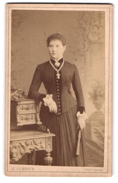 Fotografie Ernst Ulbrich, Cottbus, Ernste junge Frau in tailliertem Kleid mit F