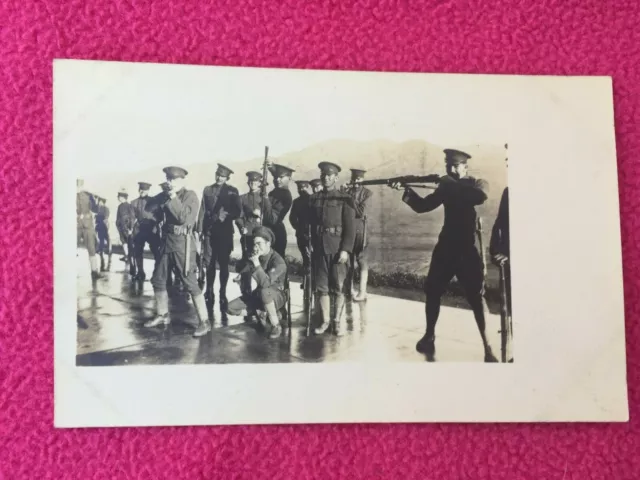 RPPC antique MILITARY vintage POSTCARD men in UNIFORM aim at camera SHOOT rifle