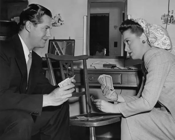 Olivia de Havilland and Robert Cummings playing cards on the se - 1942 Old Photo