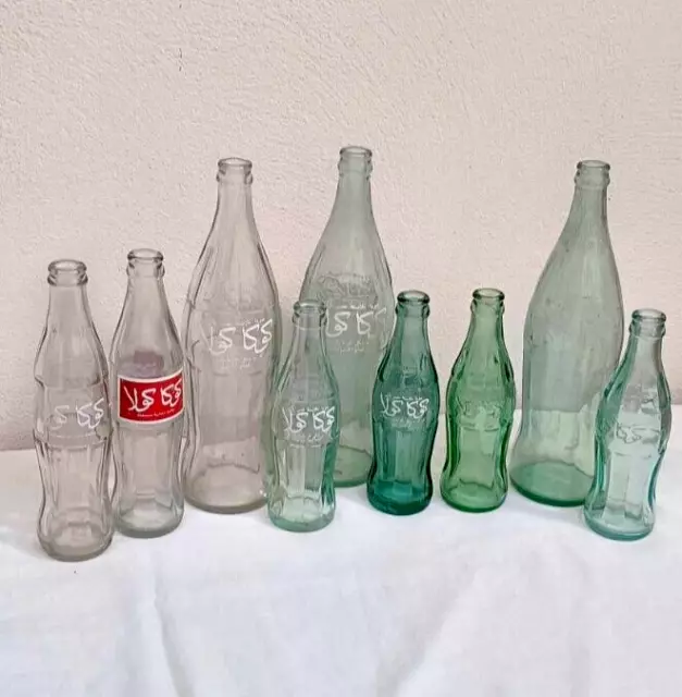 Collection of vintage Coca-Cola glass bottles of various CL arabic writting 1986
